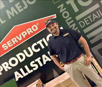 Hispanic male in front of black SERVPRO wall